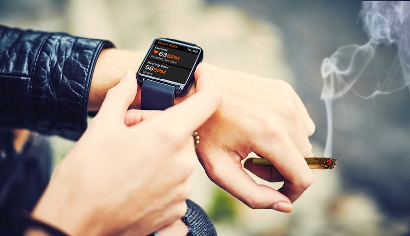 Person adjusting a smart watch while smoking a joint