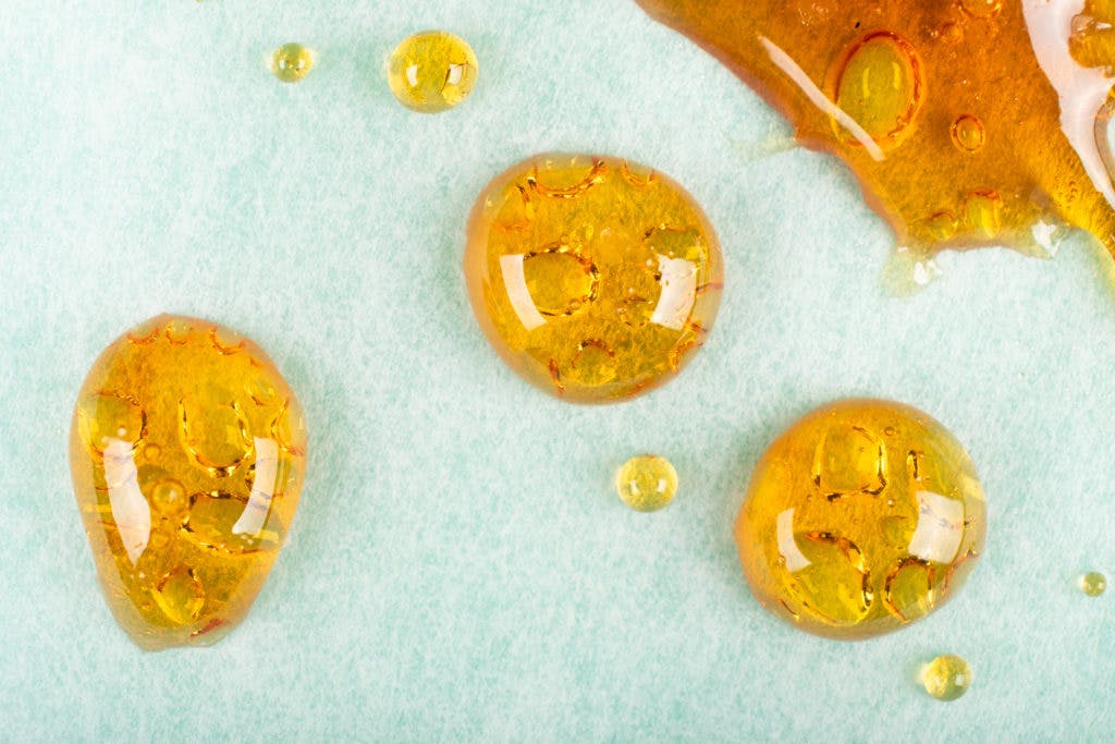 golden drops of cannabis wax macro closeup.