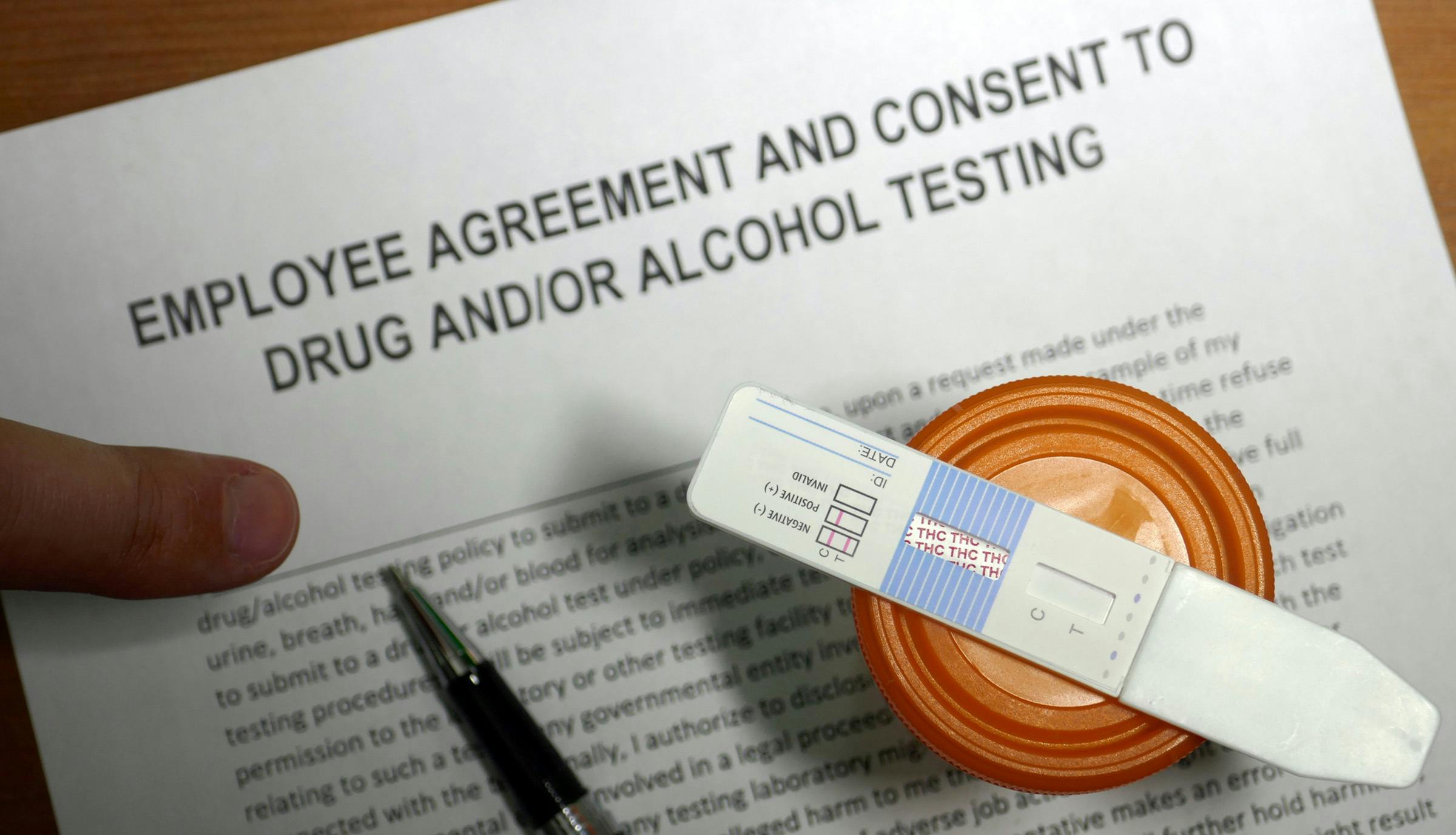 a positive drug test for THC sits on top of a employee agreement
