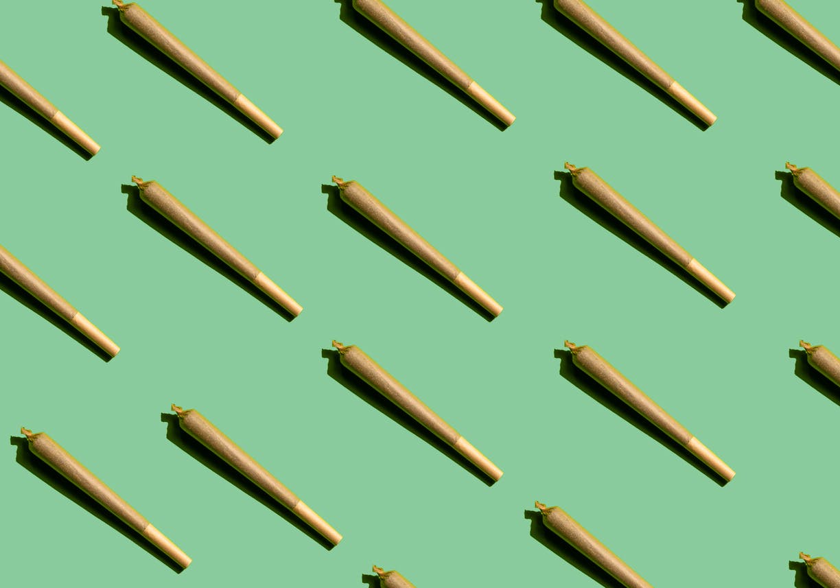 Cannabis joint pattern on green background. Concept of medical cannabis, therapeutic cannabis, alternative medicine