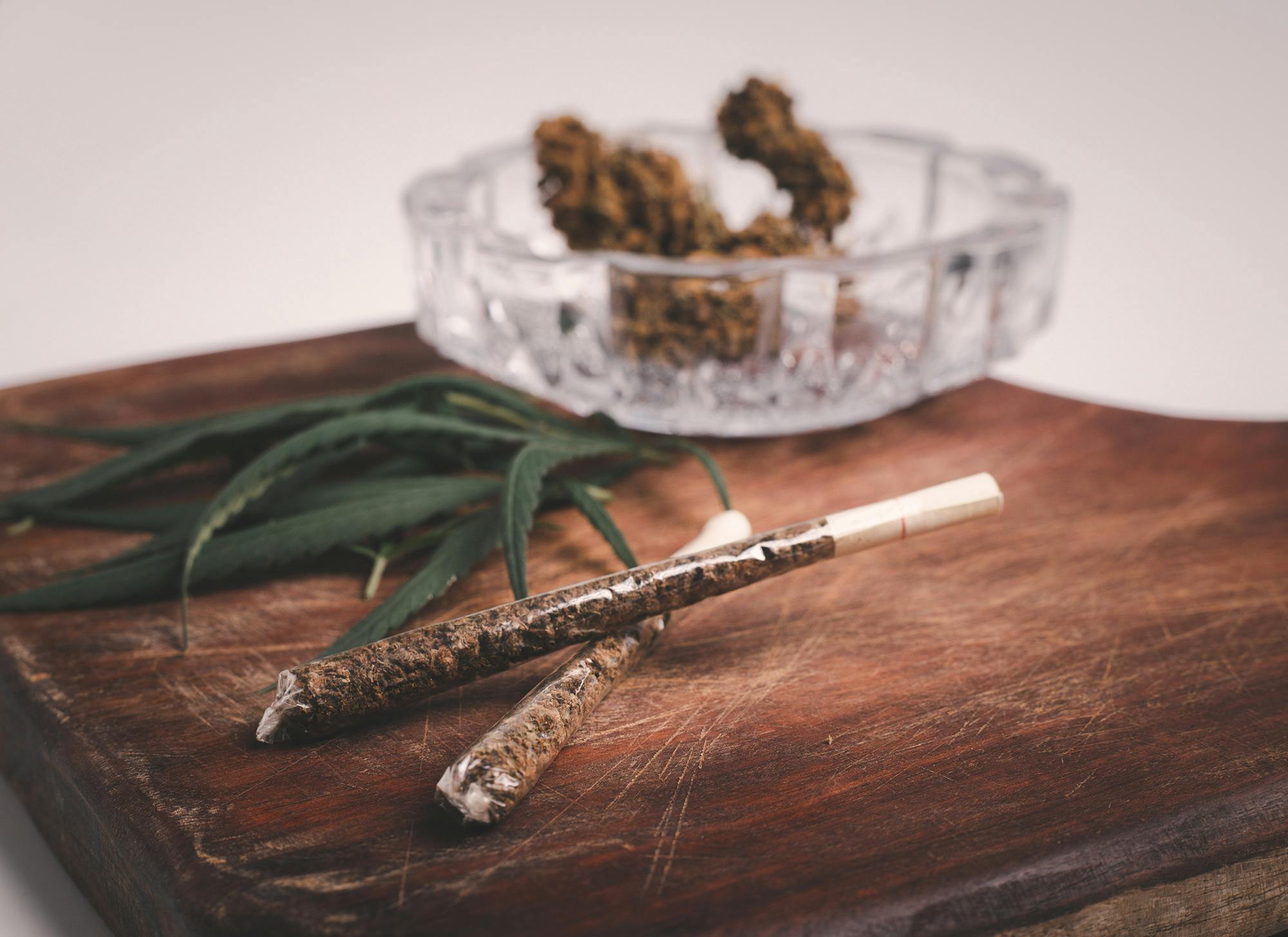 Rolled CBD medicinal marijuana and flower on wood background
