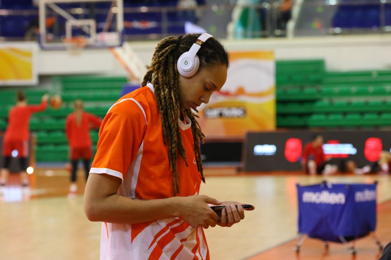 Brittney Griner listening to Beats headphones on basketball court sideline