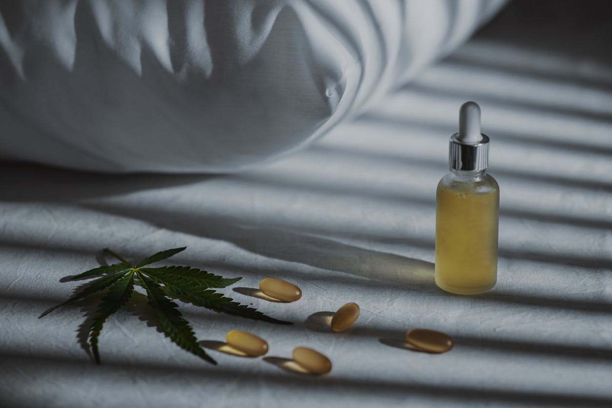 Evening bedroom with cbd oil, capsules and a cannabis branch. Melatonin production, concept to combat sleep disorders