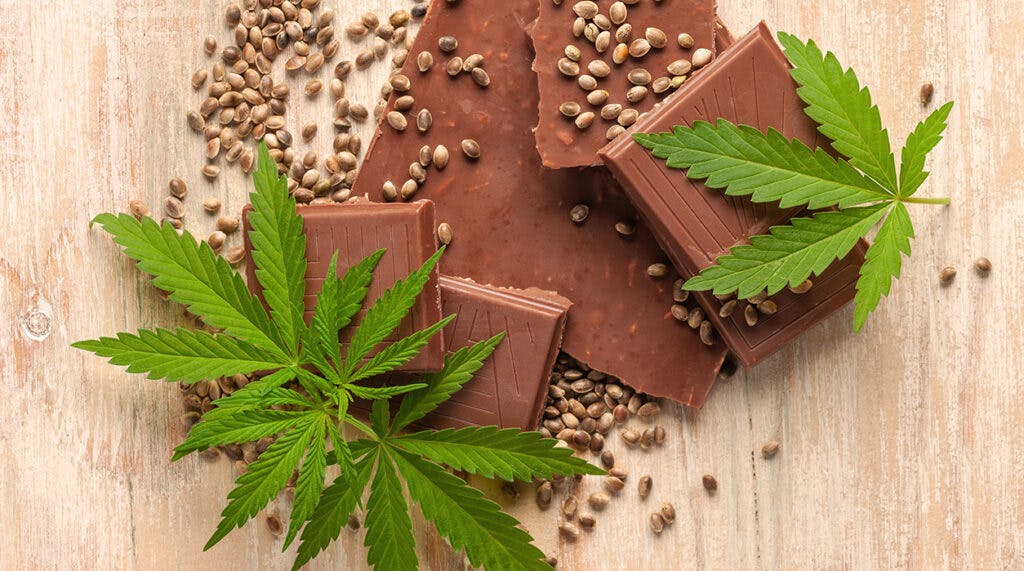 Vegan Chocolate with cannabis leaves and seeds on wooden backgro