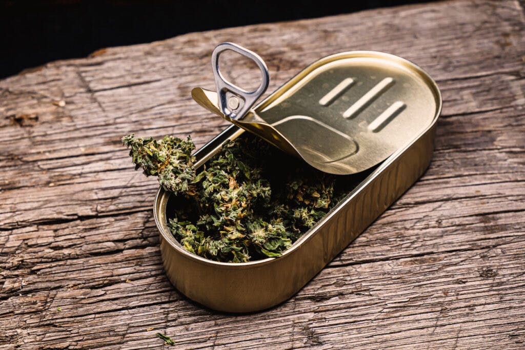 cannabis in a open tin can. on old wooden background. rustic. Horizontal orintation